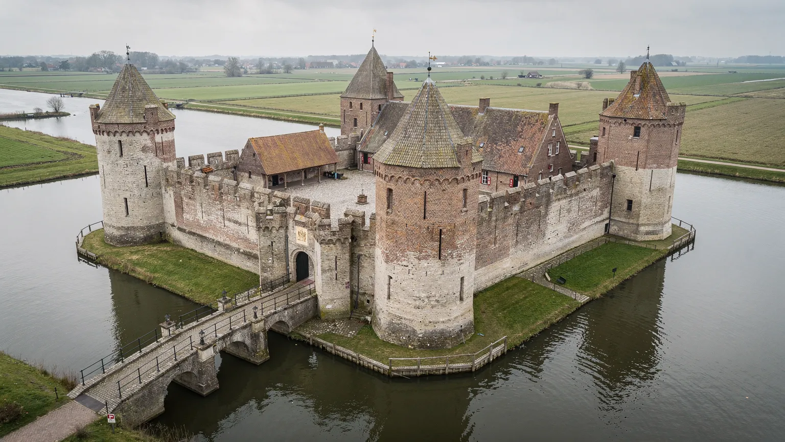Illustratie van een omgrachte middeleeuwse waterburcht met poortgebouw, torens en binnenhof